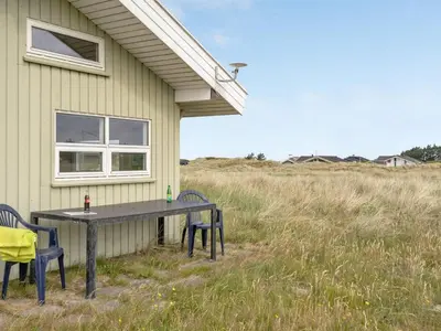 a table and chairs sitting outside of a house at Holiday Home Viktoria - 400m from the sea by Interhome in Løkken