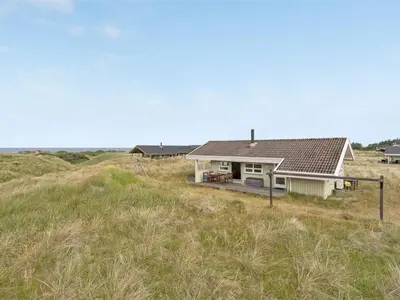 a white house in the middle of a field at Holiday Home Viktoria - 400m from the sea by Interhome in Løkken