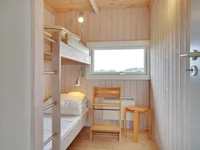 a tiny house with a bunk bed and a desk at Holiday Home Viktoria - 400m from the sea by Interhome in Løkken