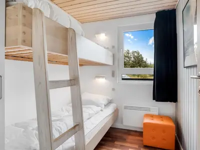 a bedroom with bunk beds and a window at Holiday Home Bengta - 200m from the sea by Interhome in Løkken