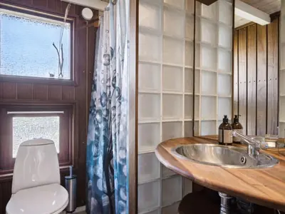 a bathroom with a sink and a toilet and a window at Holiday Home Danica - 175m from the sea by Interhome in Løkken