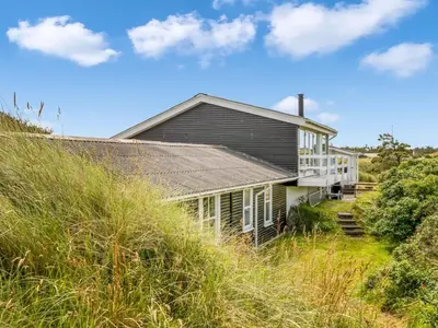a house on the side of a hill with tall grass at Holiday Home Stina - 250m from the sea by Interhome in Løkken