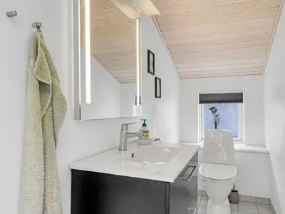 a bathroom with a sink and a toilet at Holiday Home Dimo - 700m from the sea by Interhome in Løkken