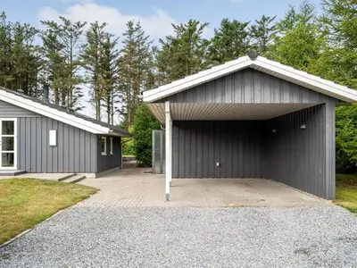 a building with a garage with a driveway at Holiday Home Dimo - 700m from the sea by Interhome in Løkken