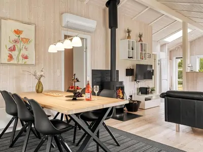 a dining room and living room with a table and chairs at Holiday Home Dimo - 700m from the sea by Interhome in Løkken