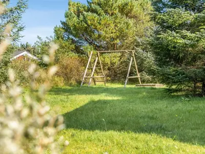 a wooden frame in the middle of a yard at Holiday Home Terho - 1km from the sea by Interhome in Løkken