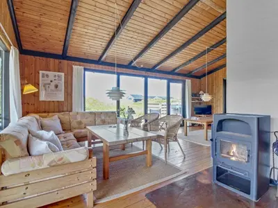 a living room with a couch and a wood stove at Holiday Home Tulir - 300m from the sea by Interhome in Løkken