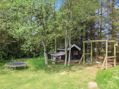 a playground with a table and a swing at Holiday Home Siljana - 1km from the sea by Interhome in Løkken