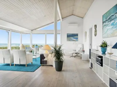 a living room with white furniture and large windows at Holiday Home Alyssa - 300m from the sea by Interhome in Løkken