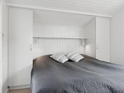 a bedroom with a bed with two pillows on it at Holiday Home Alyssa - 300m from the sea by Interhome in Løkken
