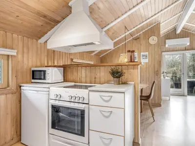 a kitchen with a white stove and a microwave at Holiday Home Seda - 600m from the sea by Interhome in Løkken