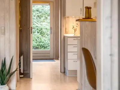 a kitchen with white cabinets and a door with a window at Holiday Home Seda - 600m from the sea by Interhome in Løkken