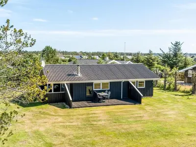 a house with a deck and a yard at Holiday Home Guja - 1km from the sea by Interhome in Løkken