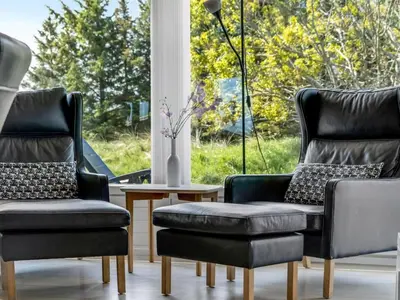 two chairs and a couch in front of a window at Holiday Home Aponi - 400m from the sea by Interhome in Løkken