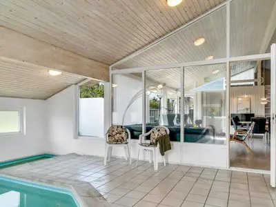 a living room with a pool and a house at Holiday Home Aponi - 400m from the sea by Interhome in Løkken