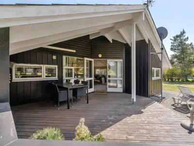 a covered deck with a table and chairs at Holiday Home Lovisa - 500m from the sea by Interhome in Løkken