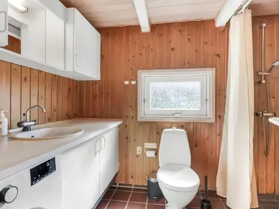 a bathroom with a toilet and a window at Holiday Home Estefania - 450m from the sea by Interhome in Løkken