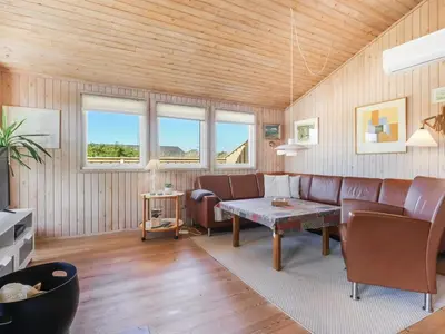 a living room with a couch and a table at Holiday Home Estefania - 450m from the sea by Interhome in Løkken