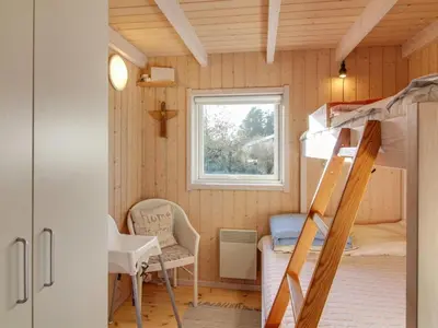 a small room with a bunk bed and a desk at Holiday Home Nynke - 600m from the sea by Interhome in Løkken