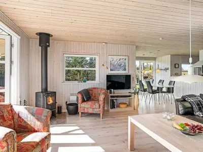 a living room with a couch and a fireplace at Holiday Home Troels - 750m from the sea by Interhome in Løkken