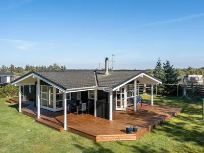 a house with a wooden deck in a yard at Holiday Home Troels - 750m from the sea by Interhome in Løkken