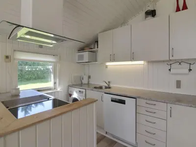 a kitchen with white cabinets and a sink at Holiday Home Eden - 800m from the sea by Interhome in Løkken