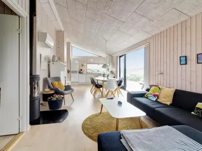 a living room with a couch and a table at Holiday Home Mikkel - 300m from the sea by Interhome in Løkken