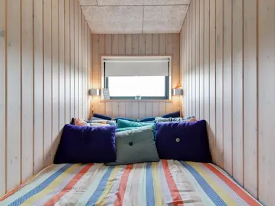 a bedroom with a couch in the corner of a room at Holiday Home Mikkel - 300m from the sea by Interhome in Løkken