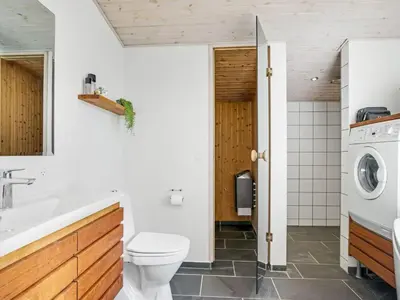 a bathroom with a toilet sink and a washing machine at Holiday Home Ingela - 350m from the sea by Interhome in Løkken