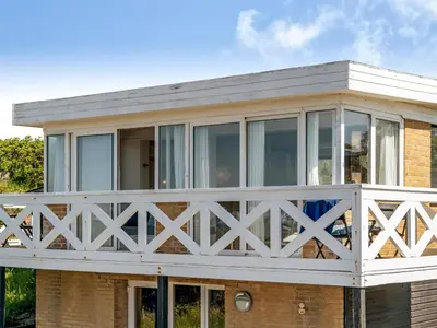 a house with a white fence around it at Holiday Home Mielikki - 200m from the sea by Interhome in Løkken