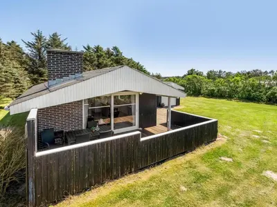 a small house with a roof on a field at Holiday Home Tonja - 300m from the sea by Interhome in Løkken