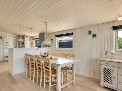 a kitchen with a white table and chairs at Holiday Home Tonja - 300m from the sea by Interhome in Løkken