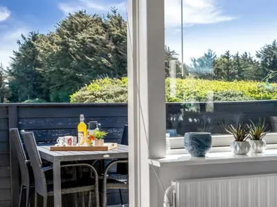 a table and chairs on a balcony with a window at Holiday Home Nayeli - 275m from the sea by Interhome in Løkken