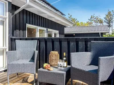 a patio with two chairs and a table at Holiday Home Elvan - 450m from the sea by Interhome in Løkken