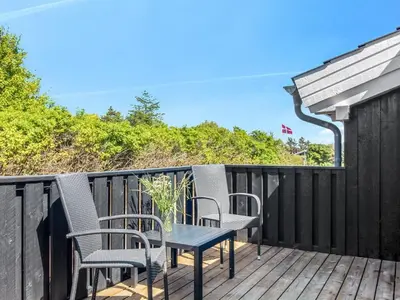 a patio with chairs and a table on a deck at Holiday Home Elvan - 450m from the sea by Interhome in Løkken