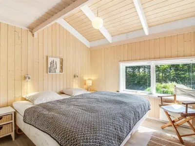 a bedroom with a large bed and a window at Holiday Home Elvan - 450m from the sea by Interhome in Løkken