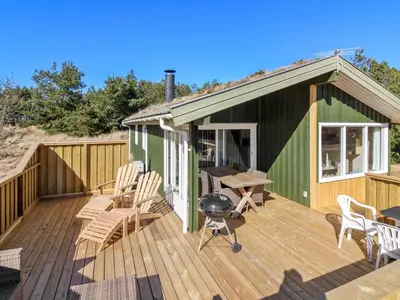 a green house with a grill on a deck at Holiday Home Taina - 1-1km from the sea by Interhome in Løkken