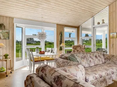 a living room with a couch and a table at Holiday Home Klakke - 900m from the sea by Interhome in Løkken