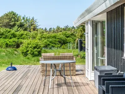 a patio with a table and chairs on a deck at Holiday Home Klakke - 900m from the sea by Interhome in Løkken