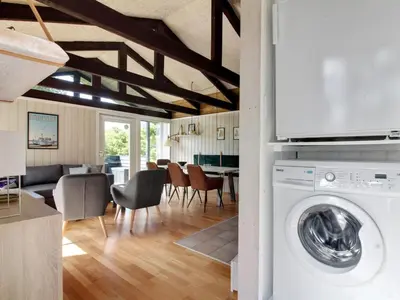 a kitchen and living room with a washing machine at Holiday Home Eyer - 800m from the sea by Interhome in Løkken