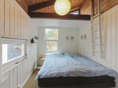 a bedroom with a bed and a lamp in it at Holiday Home Eyer - 800m from the sea by Interhome in Løkken
