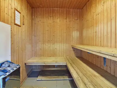 a wooden sauna with a bench in it at Holiday Home Elsemaria - 1-3km from the sea by Interhome in Løkken