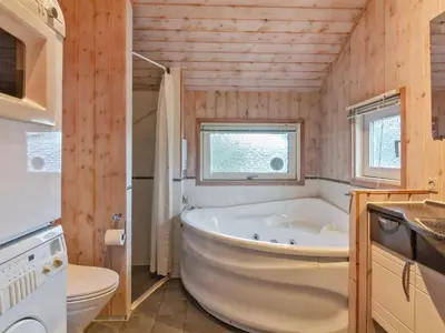 a bathroom with a tub and a toilet and a sink at Holiday Home Elsemaria - 1-3km from the sea by Interhome in Løkken