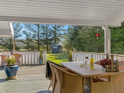 a patio with a table and chairs on a deck at Holiday Home Elsemaria - 1-3km from the sea by Interhome in Løkken