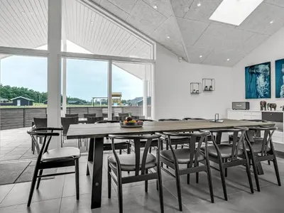 a dining room with a large wooden table and chairs at Holiday Home Fegge - 1-5km from the sea by Interhome in Løkken