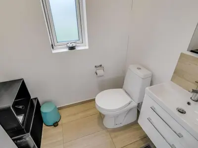 a bathroom with a white toilet and a sink at Holiday Home Eveline - 1-5km from the sea by Interhome in Løkken