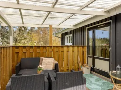 a screened in porch with a pergola and a couch at Holiday Home Lempi - 300m from the sea by Interhome in Løkken