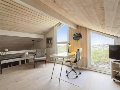a room with a desk and a chair and a tv at Holiday Home Romil - 350m from the sea by Interhome in Løkken