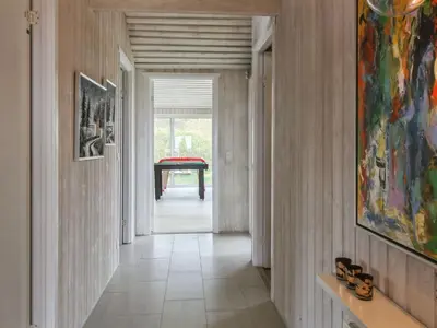 a hallway with a table and a painting on the wall at Holiday Home Romil - 350m from the sea by Interhome in Løkken