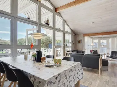 a dining room with a table and some chairs at Holiday Home Sonke - 500m from the sea by Interhome in Løkken